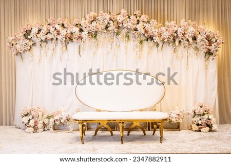 Jewish bride wedding chair, chuppah at wedding day ceremony. Flowers and vases with chaise lounge.