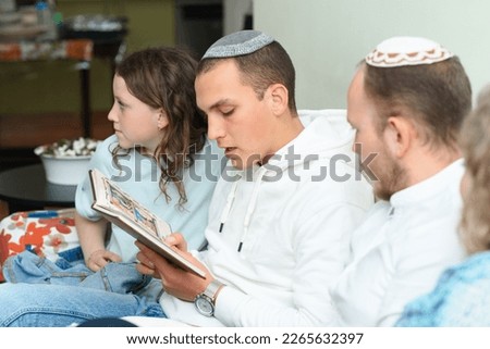 Jewish family celebrate Passover Seder reading the Haggadah. Young jewish man with kippah reads the Passover Haggadah. Foto stock © 