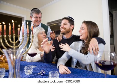 Jewish Family Celebrating Chanukah At Table With Menorah