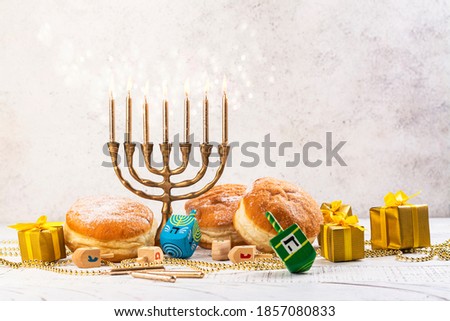 Jewish holiday Hanukkah background. Festive greeting card with gift box, menorah and dreidel spinners