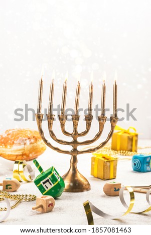 Jewish holiday Hanukkah background. Festive greeting card with gift box, menorah and dreidel spinners