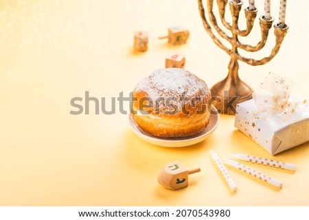 Jewish holiday Hanukkah background with menorah, candles, gifs and doughnuts. Copy space