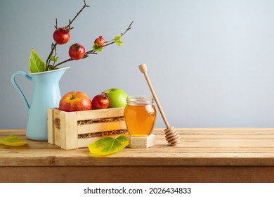 Jewish holiday Rosh Hashana background with honey jar and apples on wooden table