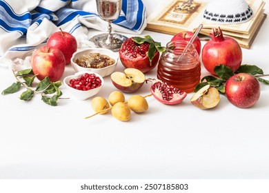 Jewish holiday Rosh Hashana festive table setting with plate, honey, apple ,pomegranates, dates, book of hebrew prayers, kiddush cup - Powered by Shutterstock