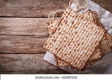 Jewish kosher matzah closeup on paper on a wooden table. horizontal view from above