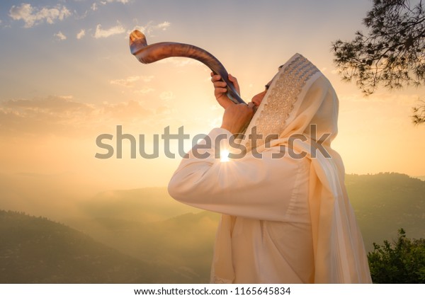 A Jewish man blowing the Shofar (ram\'s\
horn), which is used to blow sounds on Rosh HaShana (the Jewish New\
Year) and Yom Kippurim (day of\
Atonement)