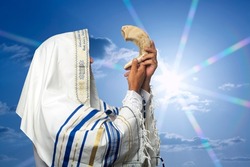 Jewish Man Rabbi In Tallit Blowing The Shofar Of Rosh Hashanah (New Year) On Sunset Time. Blowing The Shofar For The Feast Of Trumpets, Jew In Traditional Tallith Prayer Shawl Blowing The Ram's Horn