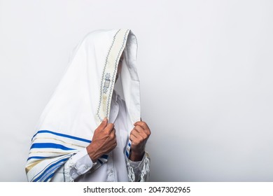 Jewish man in wrapped tallit prayer religious orthodox with prays in Jerusalem Israel. A rabbi wearing a prayer shawl in the morning. White Prayer Shawl - Tallit, jewish religious symbol.