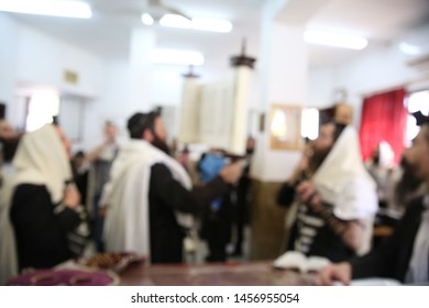 Jewish Men In Synagogue Praying, While Holding Up A Torah Scroll, Blurred