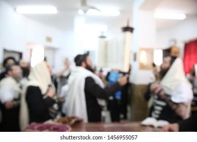 Jewish Men In Synagogue Praying, While Holding Up A Torah Scroll, Blurred