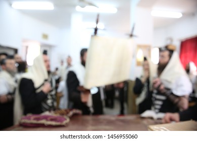 Jewish Men In Synagogue Praying, While Holding Up A Torah Scroll, Blurred