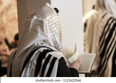 Jewish orthodox man wrapped in prayer shawl from a side view