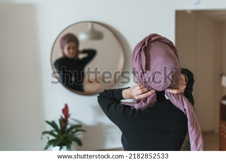Jewish religious woman ties a shawl around her head. Jewish traditions