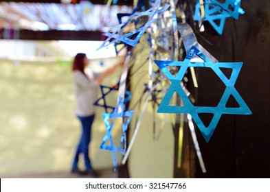 Jewish woman decorating here family Sukkah for the Jewish festival of Sukkot. A Sukkah is a temporary structure where meals are taken for the week.