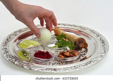 Jewish Woman Hand Organizing Passover Seder Plate With The Seventh Symbolic Item Used During The Seder Meal On Passover Jewish Holiday. No People. Copy Space