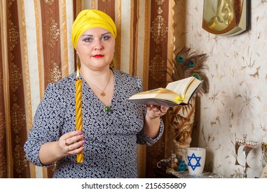 A Jewish Woman In A Kisui Rosh Headdress With A Burning Avdala Candle And A Siddur In Her Hands After Shabbat. Horizontal Photo