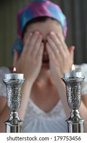 Jewish Woman Says The Blessing Upon Lighting The Sabbath Candles Before Shabbat Eve Dinner. Real People. Copy Space