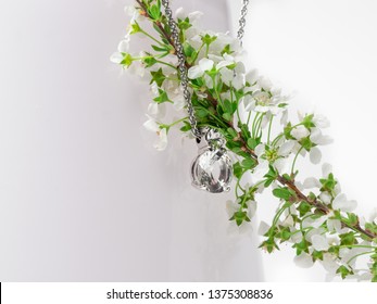 Jewlery Elements Diamond Crystal Necklace On Pure White Background With White Spring Flower With Light Green Leaves On A Light Pink Vase.