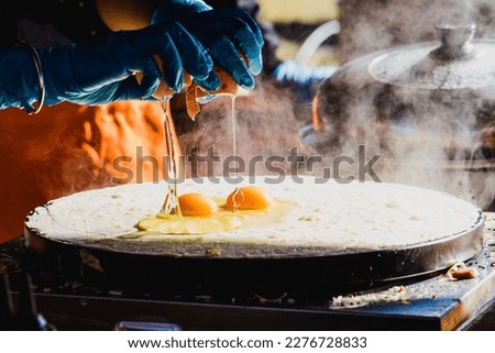 Jianbing or Jian bing (locally known as 煎饼) is a chinese crepe usually eaten at the street for breakfast. Preparation process in the image Stock fotó © 