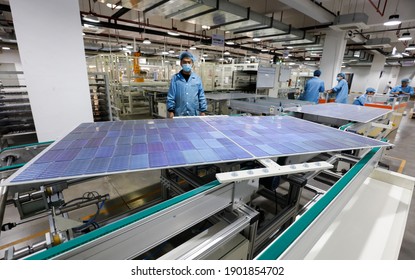 Jiangxi, China - Jan 5, 2021: Workers Operate Equipment To Produce Photovoltaic Circuit Boards At A Production Workshop Of A Green Energy Technology Company In Jiujiang, Jiangxi Province.