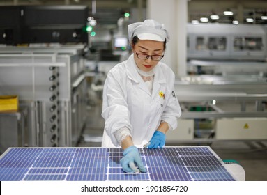 Jiangxi, China - Jan 5, 2021: Workers Operate Equipment To Produce Photovoltaic Circuit Boards At A Production Workshop Of A Green Energy Technology Company In Jiujiang, Jiangxi Province.