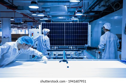 Jiangxi, China - Jan 5, 2021: Factory Workers Lifting New Solar Panel From Production Line,and  The Technician Is Checking It In The Factory.A Factory In Jiujiang City, Central China.