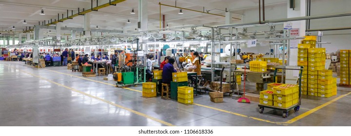 JIANGXI CHINA-March 30, 2018: Workers Operate Machines In The Workshop Production Line To Produce Electronic Accessories. A Sweaty Electronics Factory In Jiujiang, East China's Jiangxi Province.