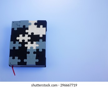 Jigsaw Puzzle Note Book On The Blue Background