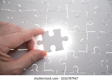jigsaw puzzle piece with light glow, business concept for completing the final puzzle piece - Shutterstock ID 1016787967
