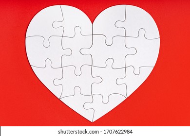 Jigsaw Puzzle Pieces In Form Of Heart On Red Background. Love, Charity, Donation, Helping Concept. Perfect Match, Reunion.