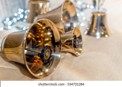 Jingle bells. Close-up of girl holding metal bell in hand and against light background - Powered by Shutterstock