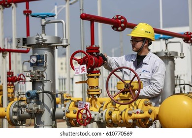 JIUJIANG CHINA-March10, 2014:A Chinese Worker Examines Natural Gas Pipes And Valves At A Gas Pressure Regulating Station In Jiujiang City, East Chinas Jiangxi Province.