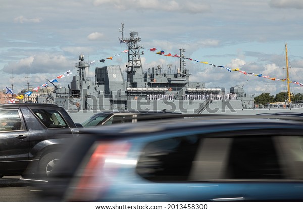 JJuly 23, 2021, Russia, St. Petersburg. The warship\
Olenegorsky miner on the Neva River in the city center. In the\
foreground, cars at speed
