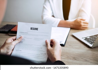 Job applicants are holding a resume document in the job interview room, job interview concept.