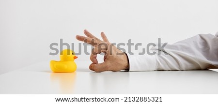Job dismissal, unemployment or being fired from a work concept. Businessman hand is about to flick the rubber duckling.