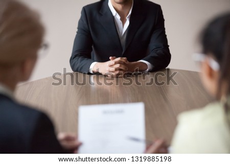 Job interview concept, african male job applicant talking to recruiters at hiring process, businessman vacancy candidate seeker meeting hr managers holding resume in office, recruitment employment