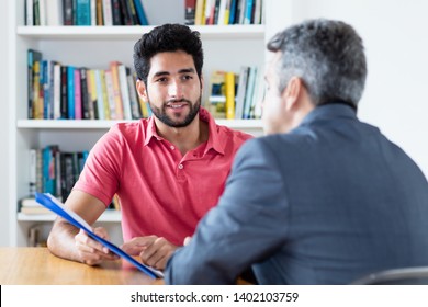 Job Interview Of North African Male Apprentice With Businessman At Office