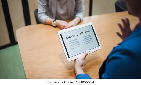 Job Interview. The Recruiter Holds A Tablet With A Check List Of The Necessary Skills Of The Candidate. Hard Skills And Soft Skills, Concept