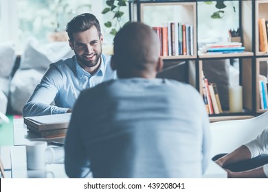 Job interview. Two young men in smart casual wear sitting at the office desk together while one of them smiling  - Shutterstock ID 439208041