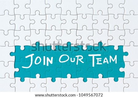 Job recruiting advertisement represented by 'JOIN OUR TEAM' texts on the jigsaw puzzle board. Rows of jigsaw pieces are removed appealing blue green background - metaphor to represent hiring positions