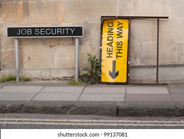 Job Security Concept Involving British Signage Words On A Pavement With Block Wall Behind