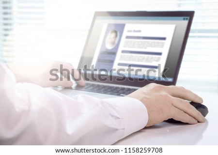 Job seeker and applicant writing his resume and CV with laptop. Modern and visual electronic curriculum vitae in social media. Work experience document in computer screen. Job search and unemployment.