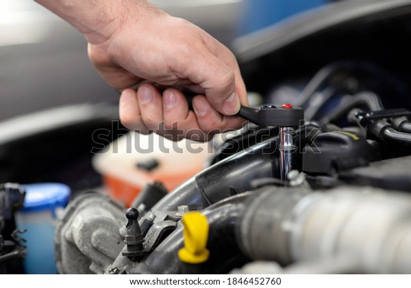 job and workplace - mechanic in a workshop repairing a\
car 