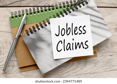 JOBLESS CLAIMS gray notepad and pen. text on writing paper - Shutterstock ID 2394771489
