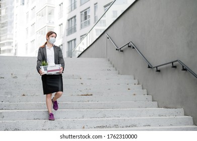 Jobless Woman Goes Down The Stairs On The Street With A Box Of Personal Items. Female Employee In Medical Mask Fired Due To Financial Crisis In Coronovirus. Unemployment.Bankruptcy.