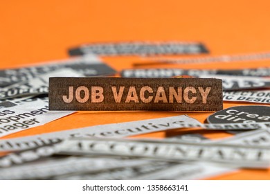 Jobs Or Careers Concept: Multiple Job Titles Or Occupations Cut Off From Newspaper With Job Vacancy A The Centre Of The Pile