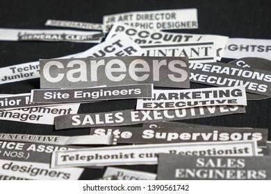 Jobs Or Careers Concept: Multiple Job Titles Or Occupations Cut Off From Newspaper With Careers On Top Of The Pile And On Black Background