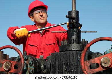 Jobs With the Oil and Gas Industry.Oil industry worker with personal protective equipment using hand tool at oil well