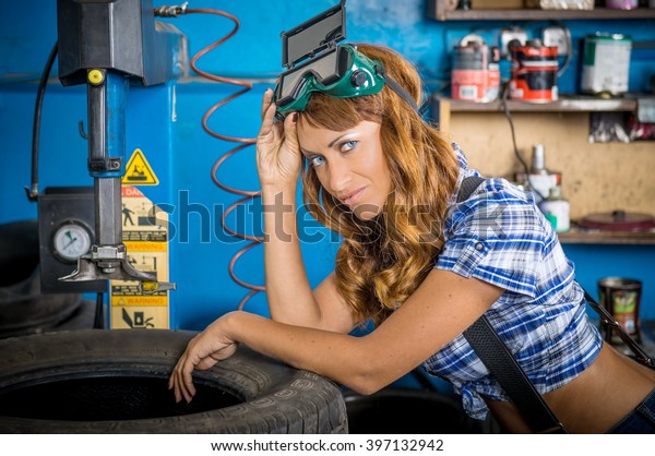 Jobs in the service station. The girl in the mask\
working at the bench. Hard work for women, seven days a week.\
Female mechanic at work. auto service station, working girl. woman\
working in garage