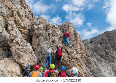 Grödner Joch, South Tyrol/Italy - 04.09.2018: Mountain Guide With Guests Climbing On The Rock Of The Via Ferrate Of The Mountain Cir.